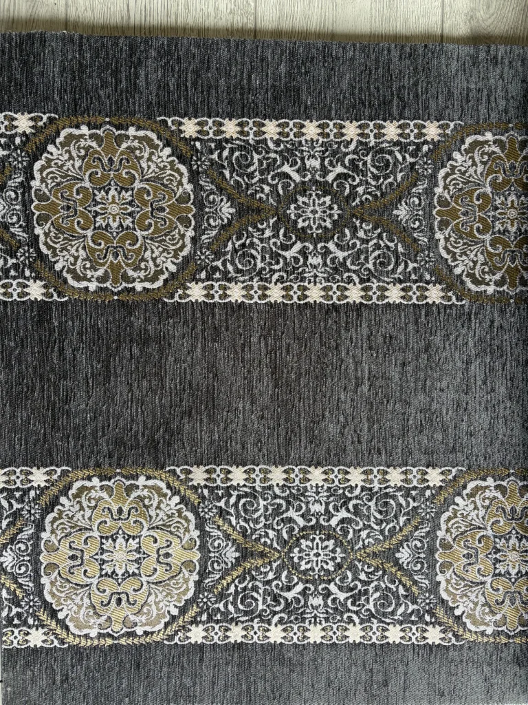 Anthracite chenille upholstery fabric with two ornamental bands of white and gold round medallions