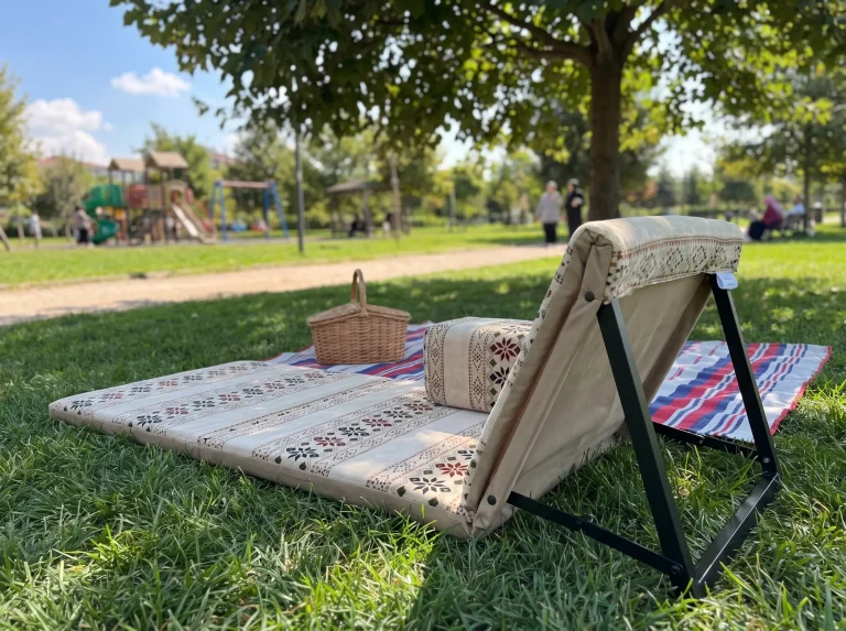 Beige folding Arabic sunbed lounger with armrest block and wicker basket on a park lawn