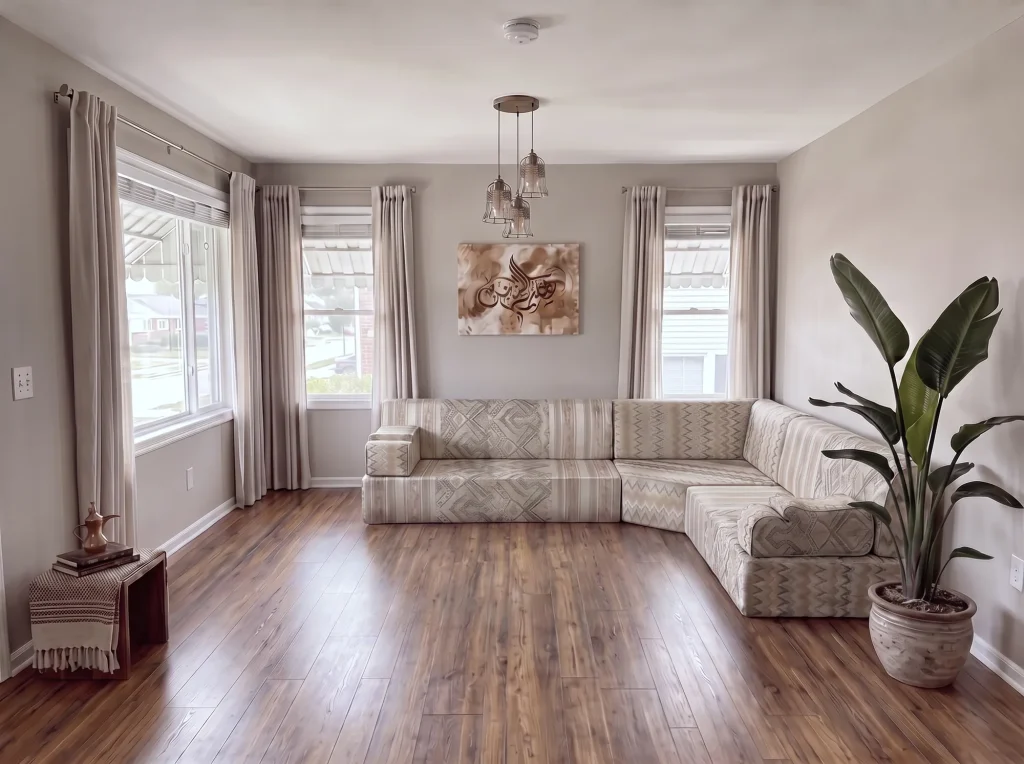 Beige flame-kilim L-shaped Arabic majlis in the corner of a grey living room with wood flooring