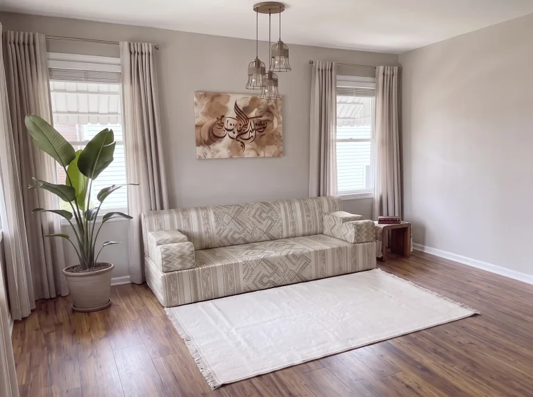 Single beige striped and kilim-pattern majlis sofa with a cream rug in a bright grey living room