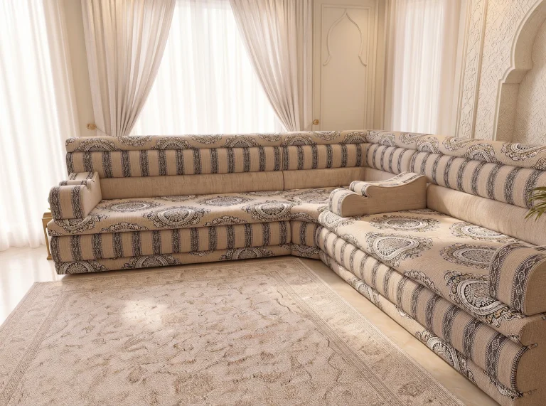 Beige L-shaped Arabic majlis with medallion seats and striped edges seen along the right-hand run