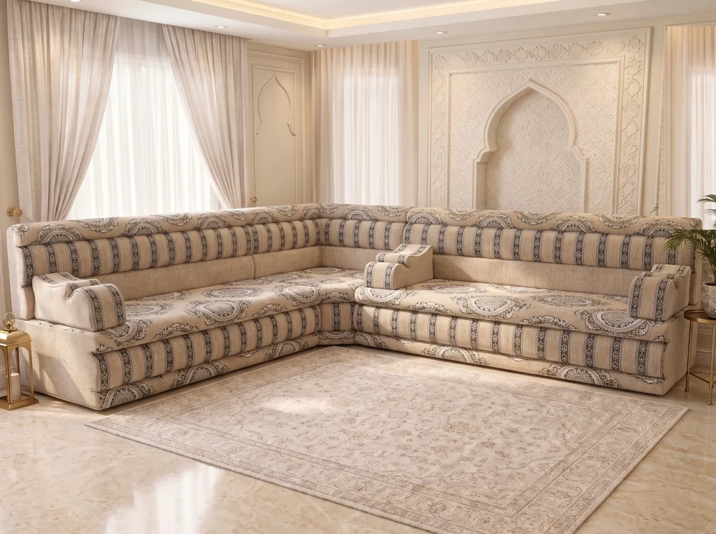 L-shaped beige Arabic majlis with medallion seats and charcoal-striped backrests on a marble floor