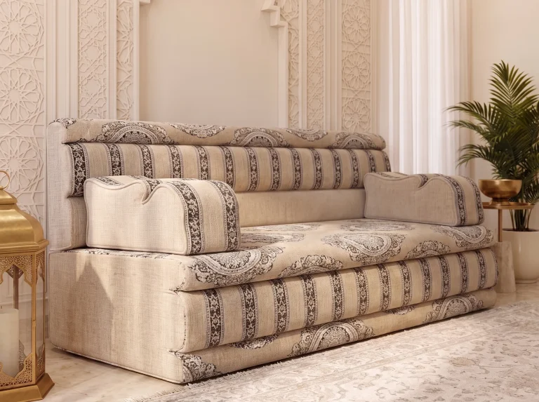 Beige majlis sofa with charcoal medallion seat and striped mattress edges viewed closely from the left