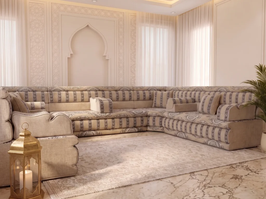 Beige medallion U-shaped majlis sofa viewed past a brass lantern on a marble floor