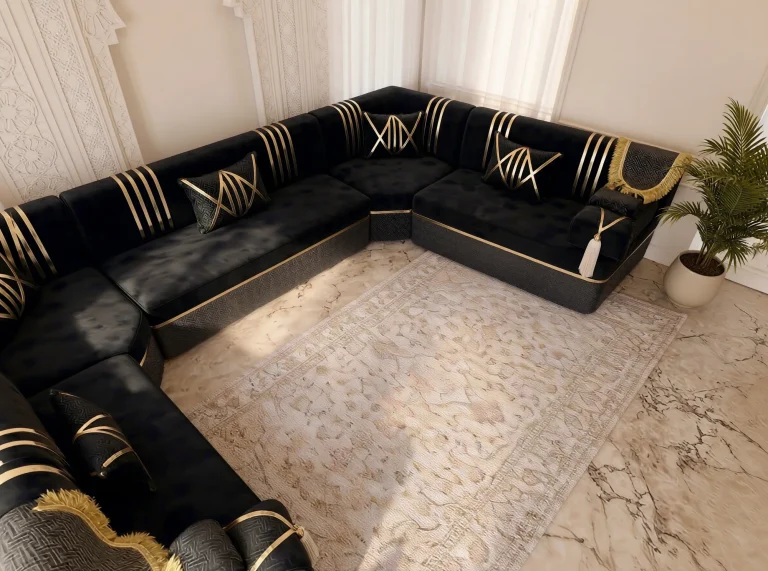 High-angle corner view of a black velvet majlis sofa with gold stripes on three sides of a cream rug