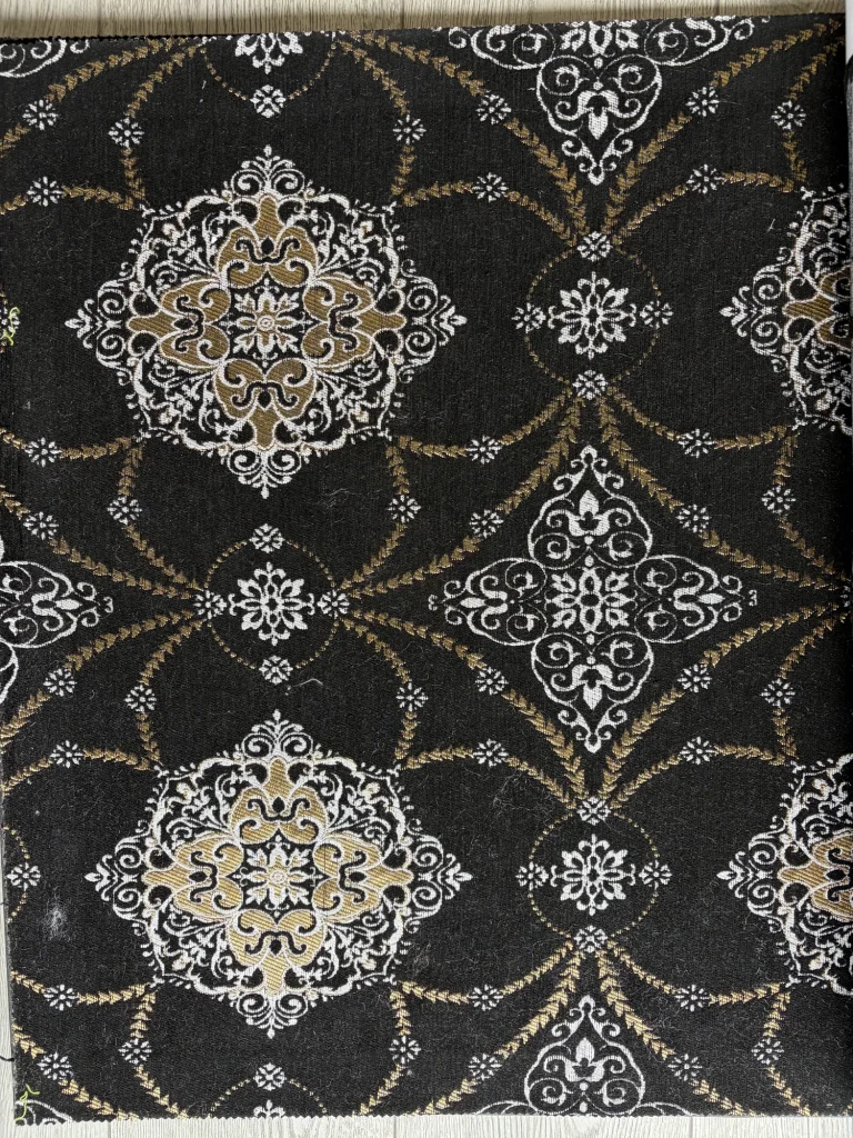Black jacquard upholstery fabric with white and gold medallions linked by leafy lattice lines