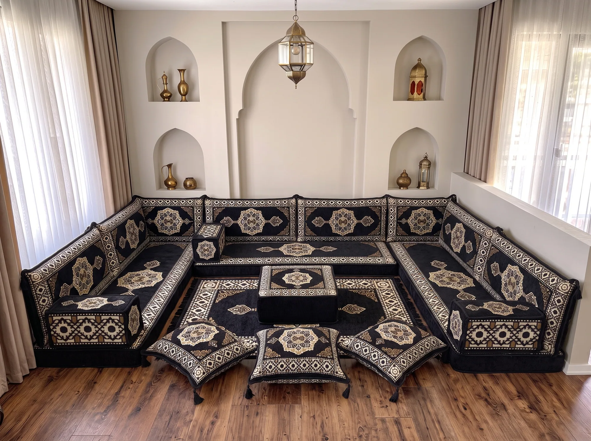 Black and gold medallion Arabic floor couch in a U shape with ottoman, rug and three floor cushions