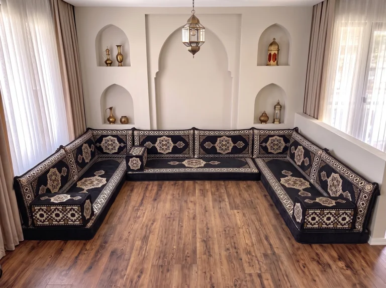 Black and gold medallion floor sofa set in a U shape along three walls, on a bare wooden floor