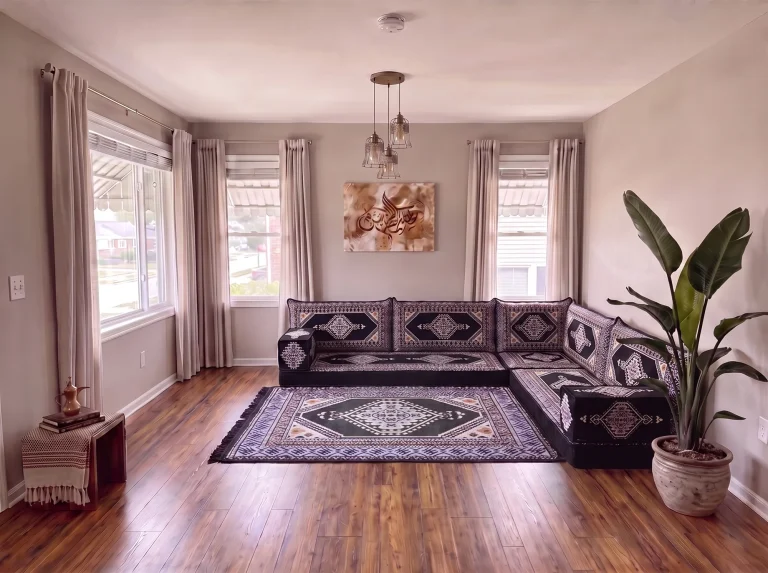 Black kilim Arabic floor couch in an L shape with a matching black and gray diamond rug in a living room
