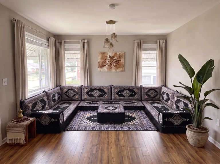 Black kilim Arabic floor couch in a U shape with a square ottoman on a matching rug in the centre