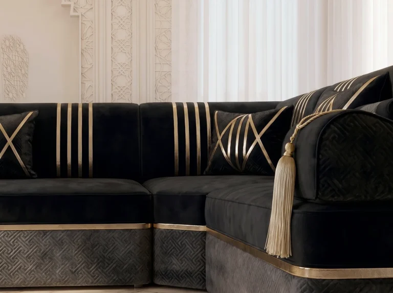 Close-up of a black velvet majlis sofa corner with gold stripes, a cream tassel and a charcoal patterned base