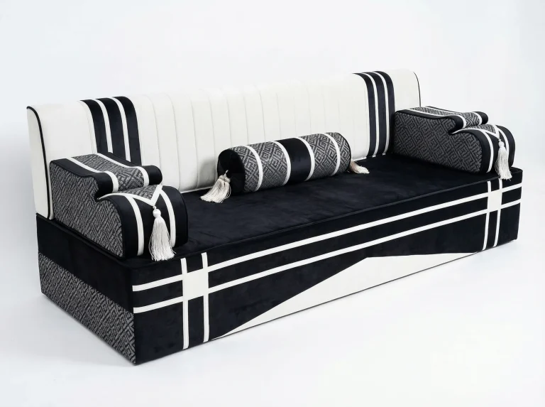 Black and white velvet Arabic jalsa seat with a channelled white backrest, grey key-pattern armrests and a bolster