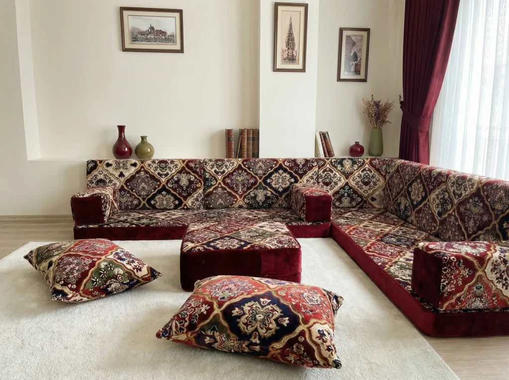Burgundy carpet-pattern floor sofa set in an L shape with an ottoman and two floor cushions in front