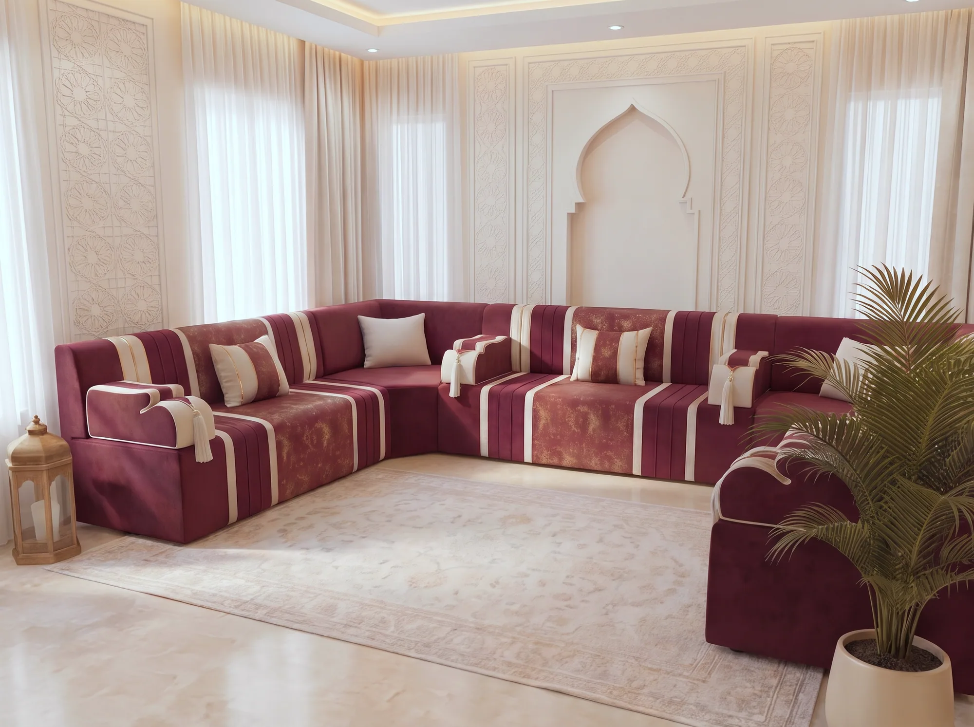 Burgundy and cream U-shaped Arabic majlis with tasselled armrests around a pale rug, seen at an angle