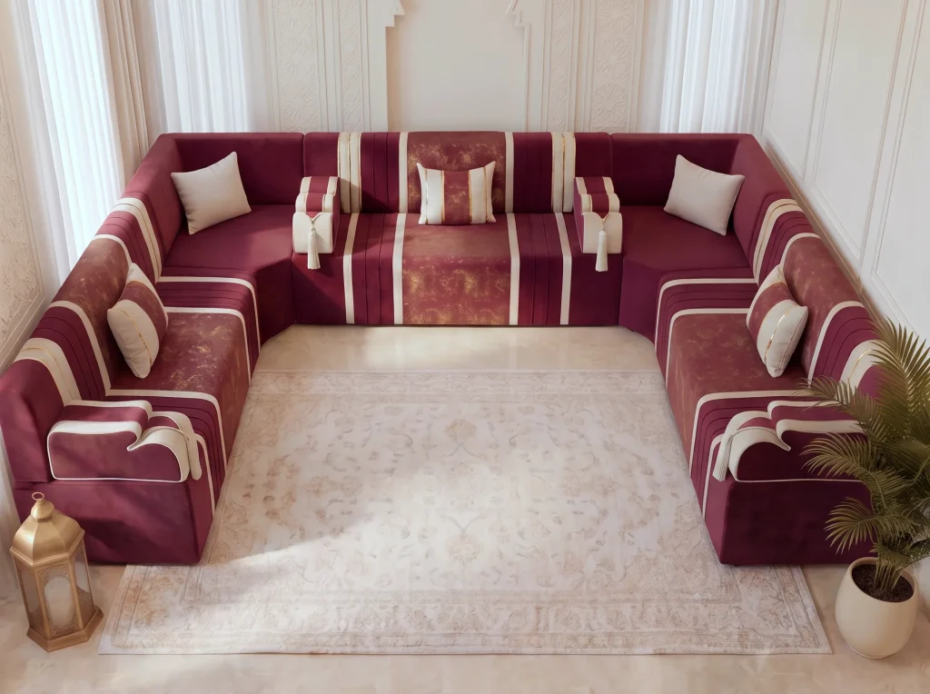 Elevated view of a burgundy U-shaped majlis sofa with cream stripes around a cream rug