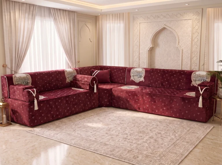Burgundy velvet majlis seating in an L shape with tapestry panels and tasselled armrests on a cream rug