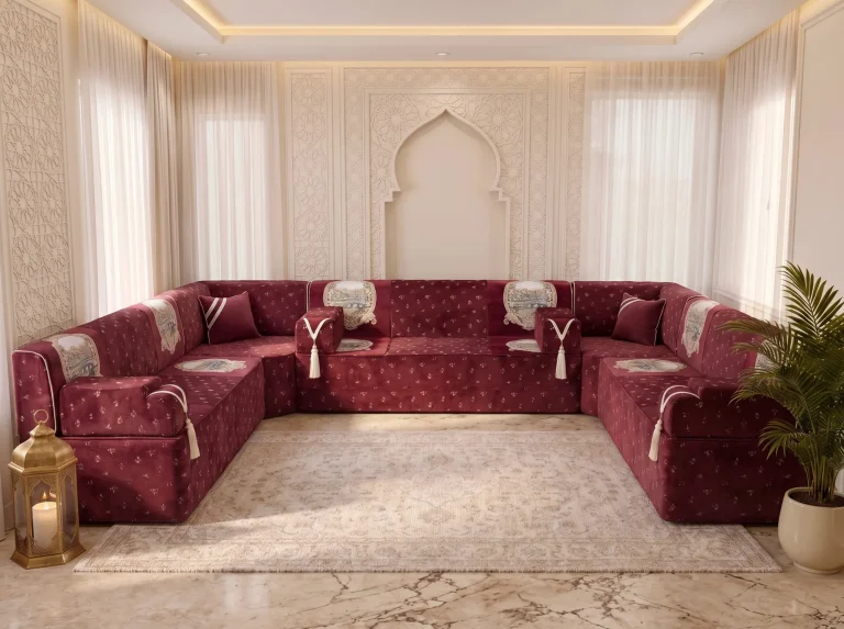 Burgundy floral velvet majlis sofa set in a U shape with cream tassel armrests under a carved arch