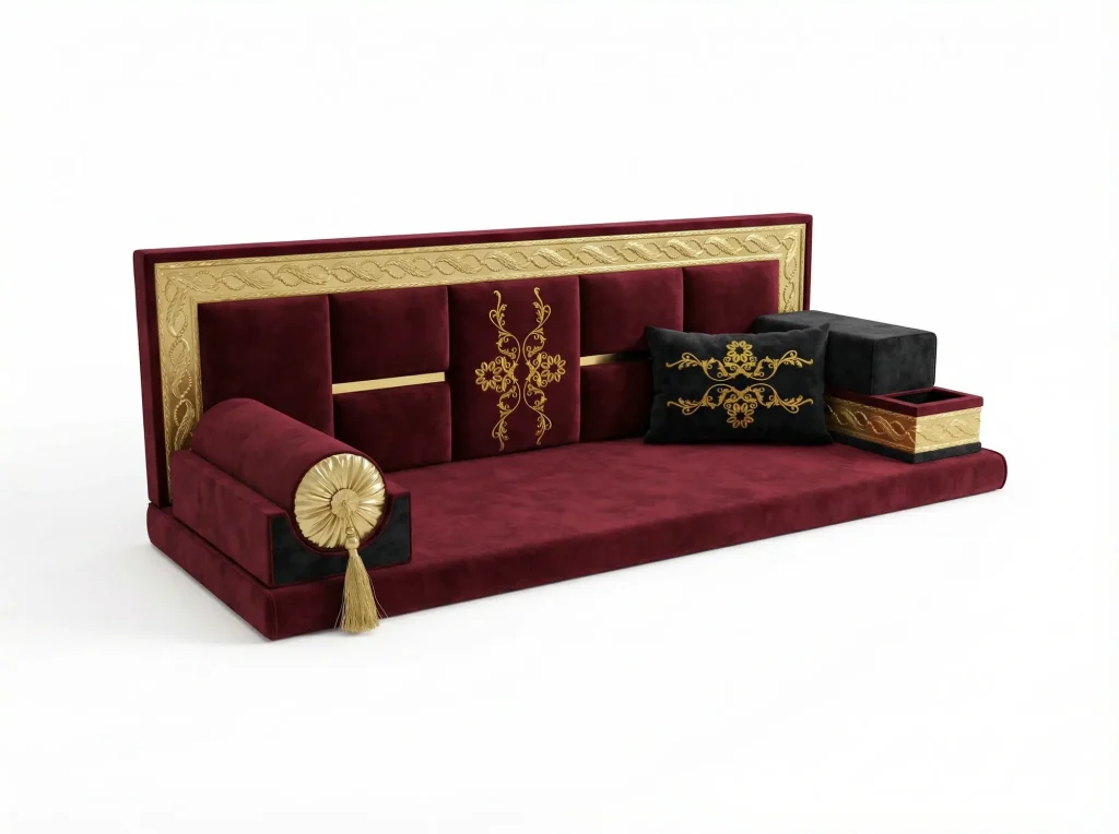 Burgundy velvet Arabic majlis seat with a gold embossed frame, gold floral embroidery and a black embroidered cushion
