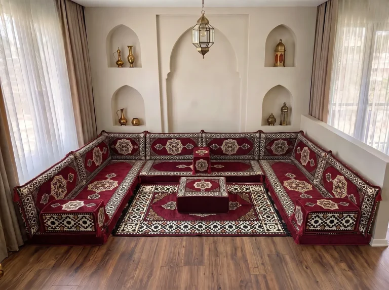 Burgundy medallion U-shaped floor sofa set with matching rug and ottoman in a niche-walled reception room