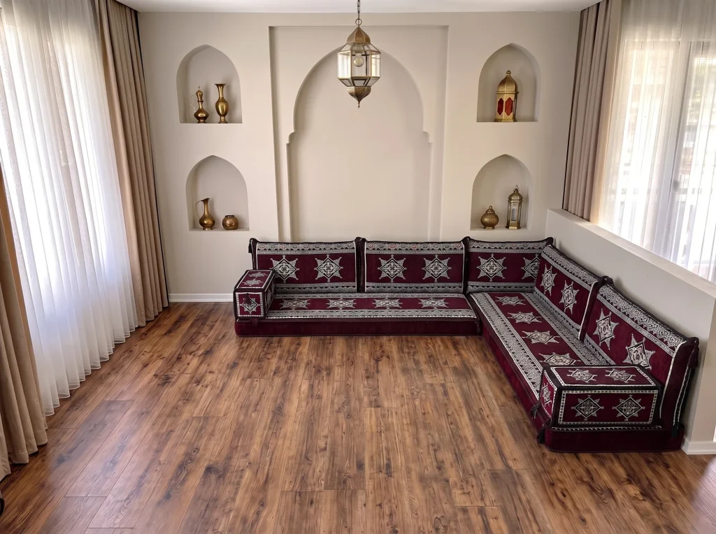 Burgundy star-pattern floor sofa with cream star motifs in an L shape on a bare wooden floor below arched niches