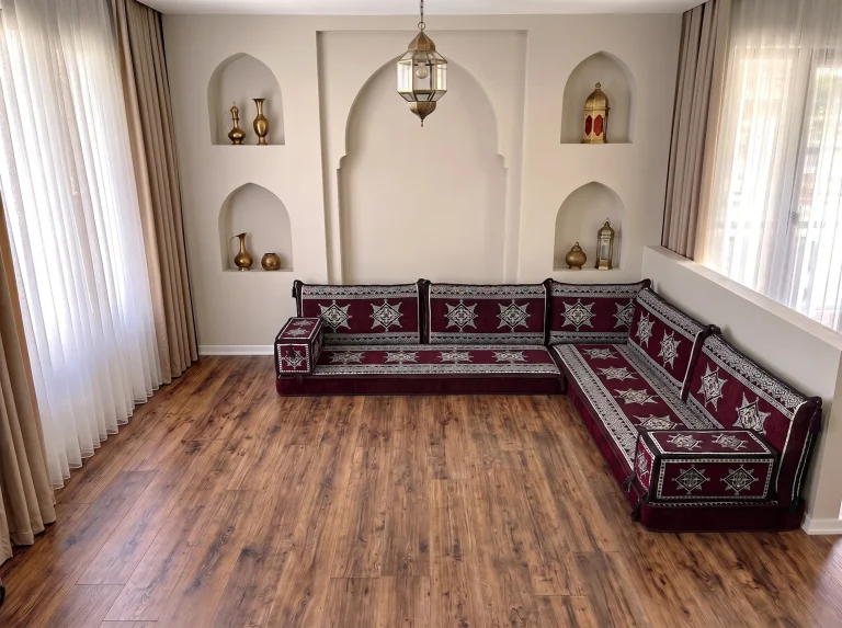 Burgundy star-pattern floor sofa with cream star motifs in an L shape on a bare wooden floor below arched niches