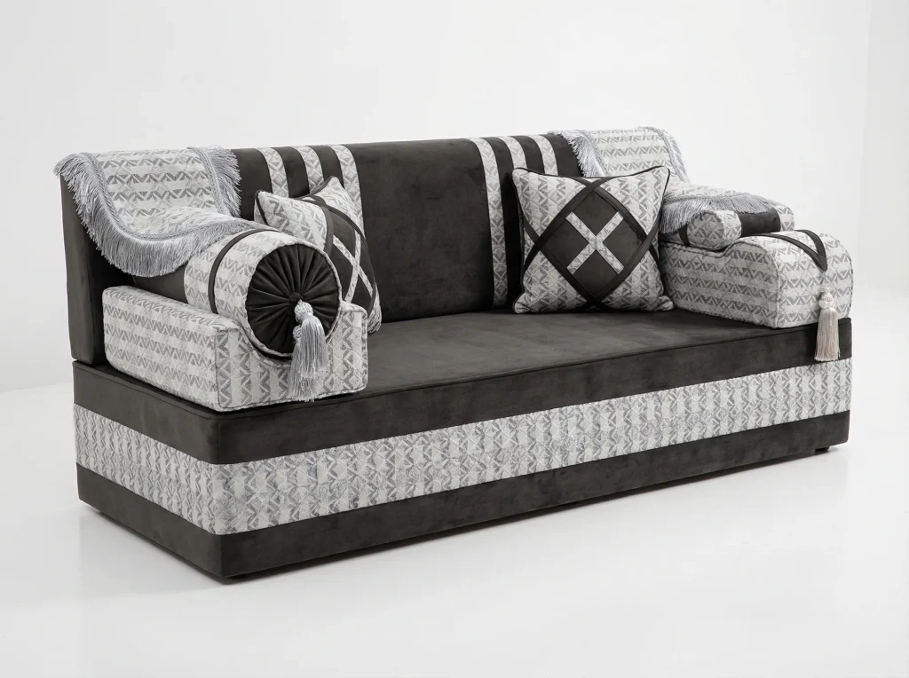 Charcoal velvet Arabic majlis module with silver geometric jacquard bands, fringed throws and a tasselled bolster