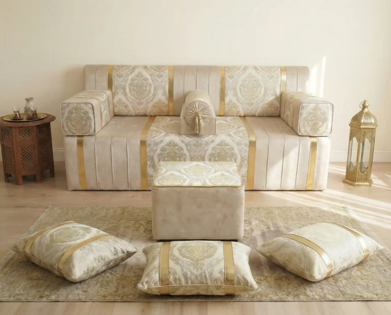 Ivory and gold damask diwan floor sofa with a square pouf and three gold-banded floor cushions arranged on a pale rug