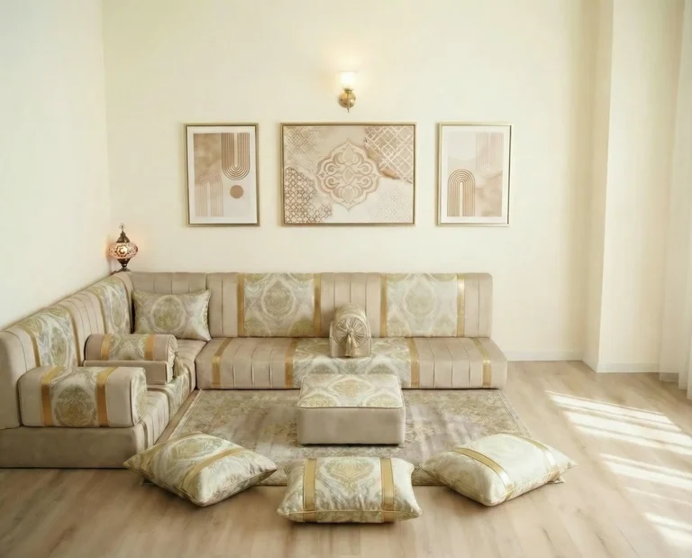 Low ivory and gold damask diwan floor sofa in an L shape with pouf and floor cushions in a bright daylit room