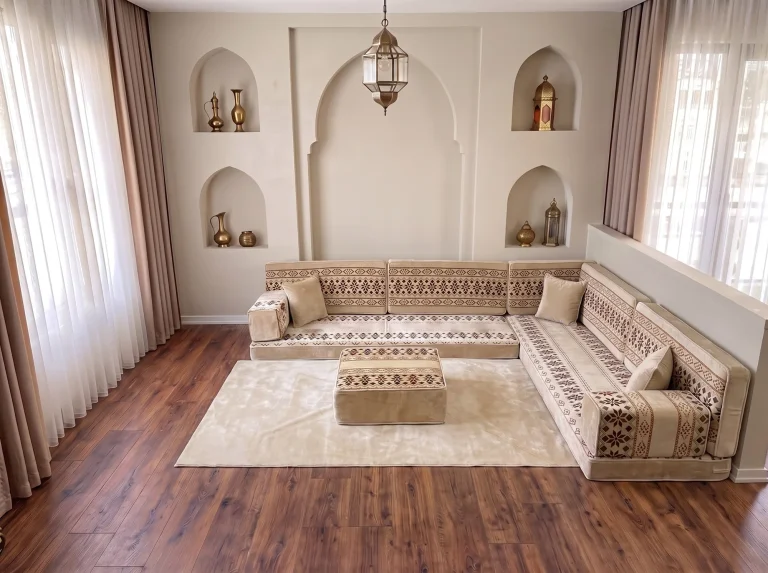 Cream floor sofa set with burgundy cross-stitch bands in an L shape with matching rug and ottoman by arched niches