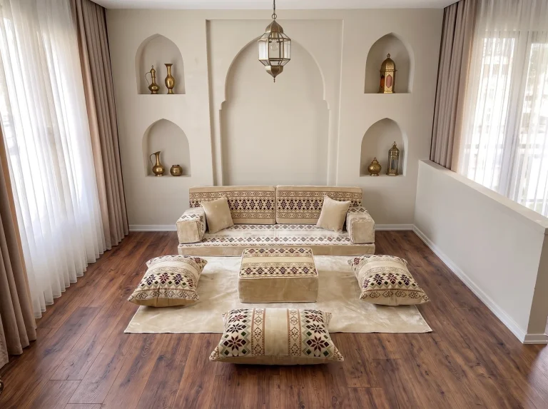 Cream velvet Arabic floor sofa with burgundy cross-stitch bands as a single row with rug, ottoman and floor cushions