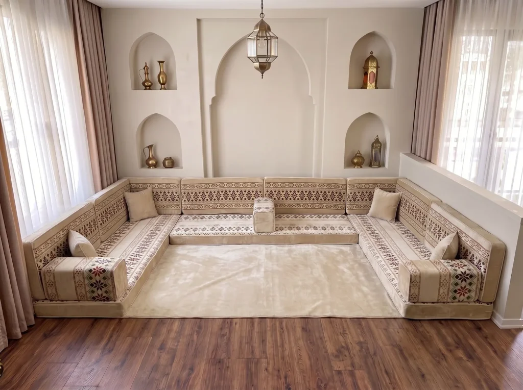 Cream and burgundy Arabic floor sofa in a U shape around a plain cream rug in a room with arched wall niches