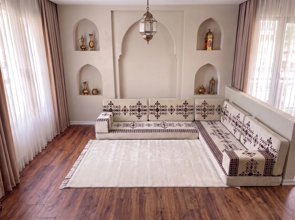 Cream sadu-pattern Arabic floor couch in an L shape with a large plain cream fringed rug in an arched room