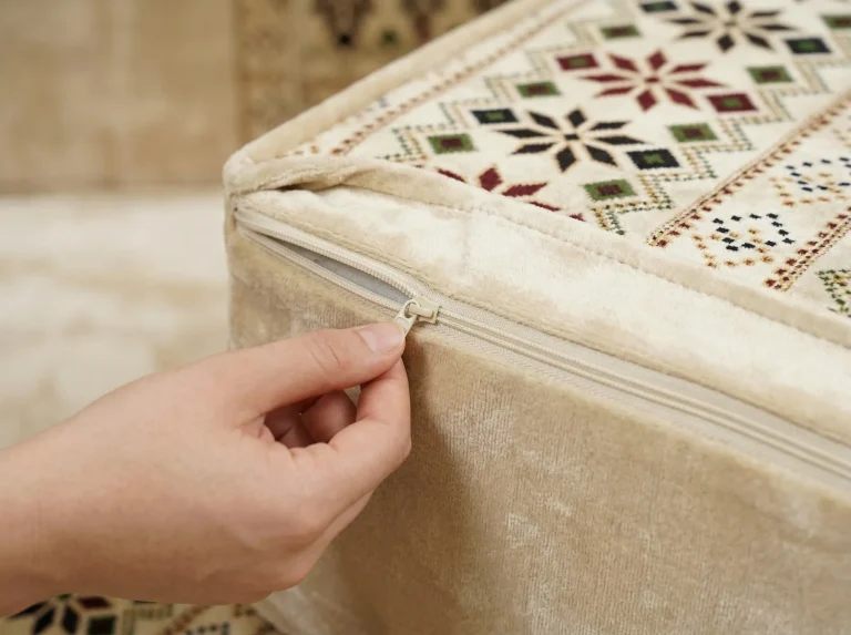 Fingers opening the zip on a cream star-pattern seat cushion to show the removable upholstery cover