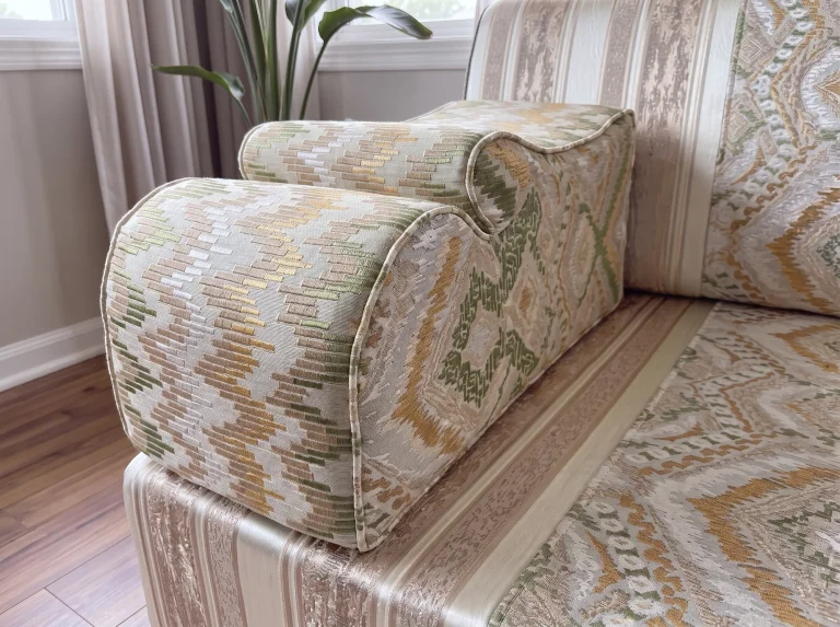 Close-up of a scalloped armrest in sage green and gold flame-kilim jacquard on a majlis seating set