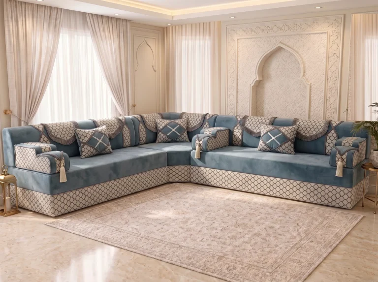 L-shaped dusty blue Arabic majlis with ivory trellis trim and tasselled armrests on a marble floor