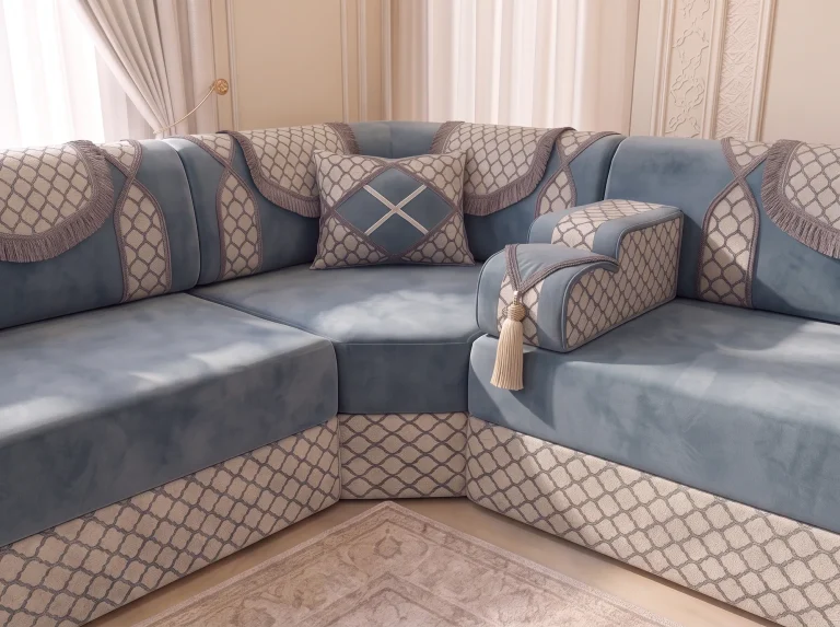 Corner of a dusty blue velvet majlis sofa with fringed trellis drapes and a tasselled armrest, close up
