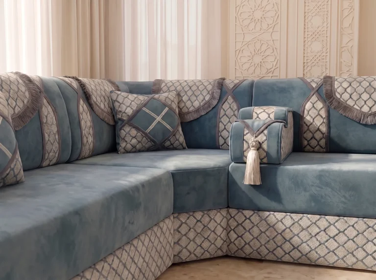 Close-up of dusty blue velvet majlis sofa cushions with ivory trellis panels and grey fringe