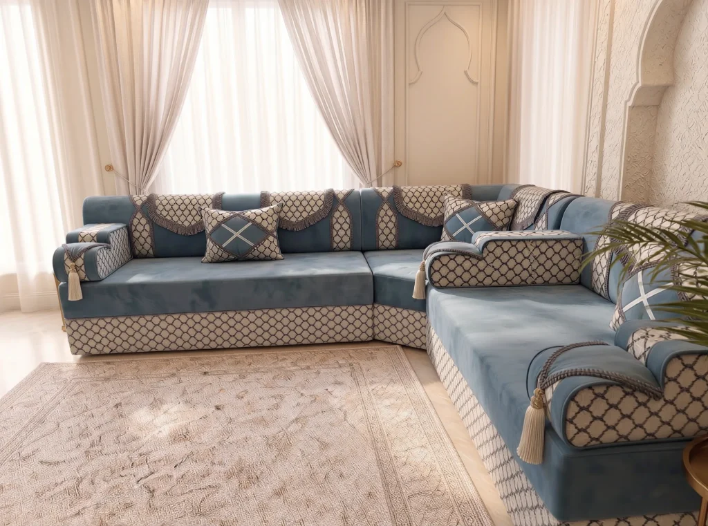Dusty blue velvet L-shaped Arabic majlis with trellis armrests and cream tassels in front of tied curtains
