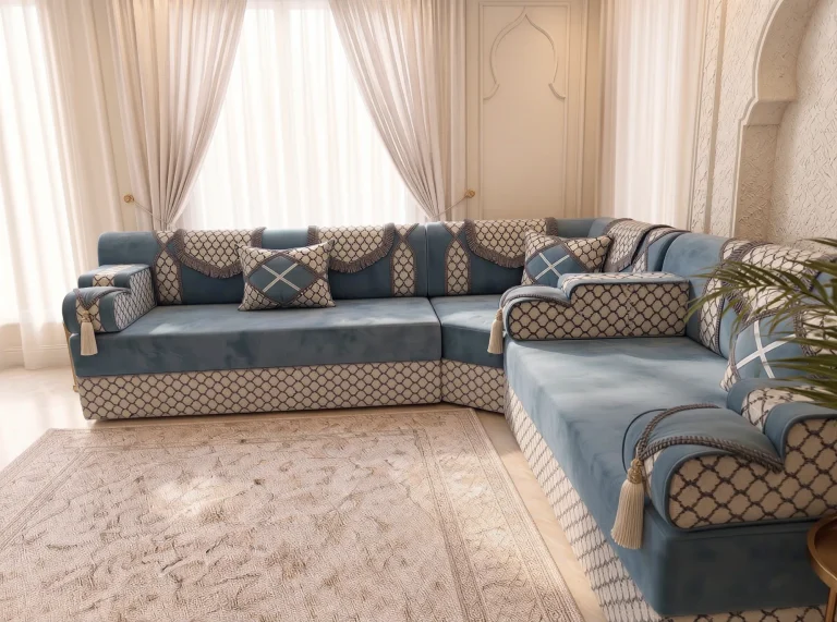 Dusty blue velvet L-shaped Arabic majlis with trellis armrests and cream tassels in front of tied curtains