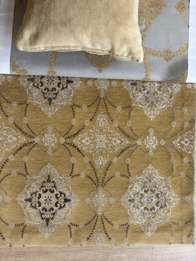Gold chenille jacquard upholstery fabric with repeating white and brown medallions and garlands