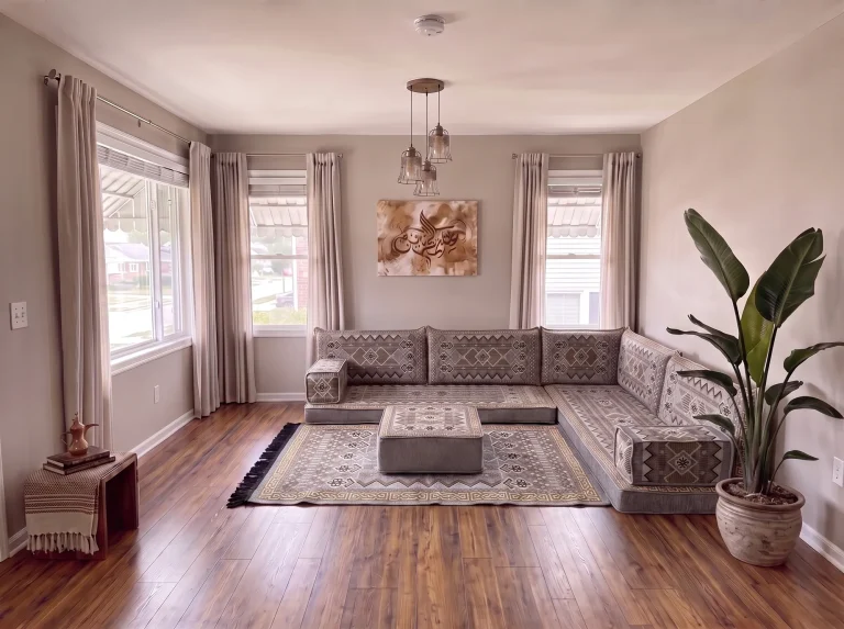 Gray and gold geometric Arabic floor couch in an L shape with matching rug and ottoman in a bright living room