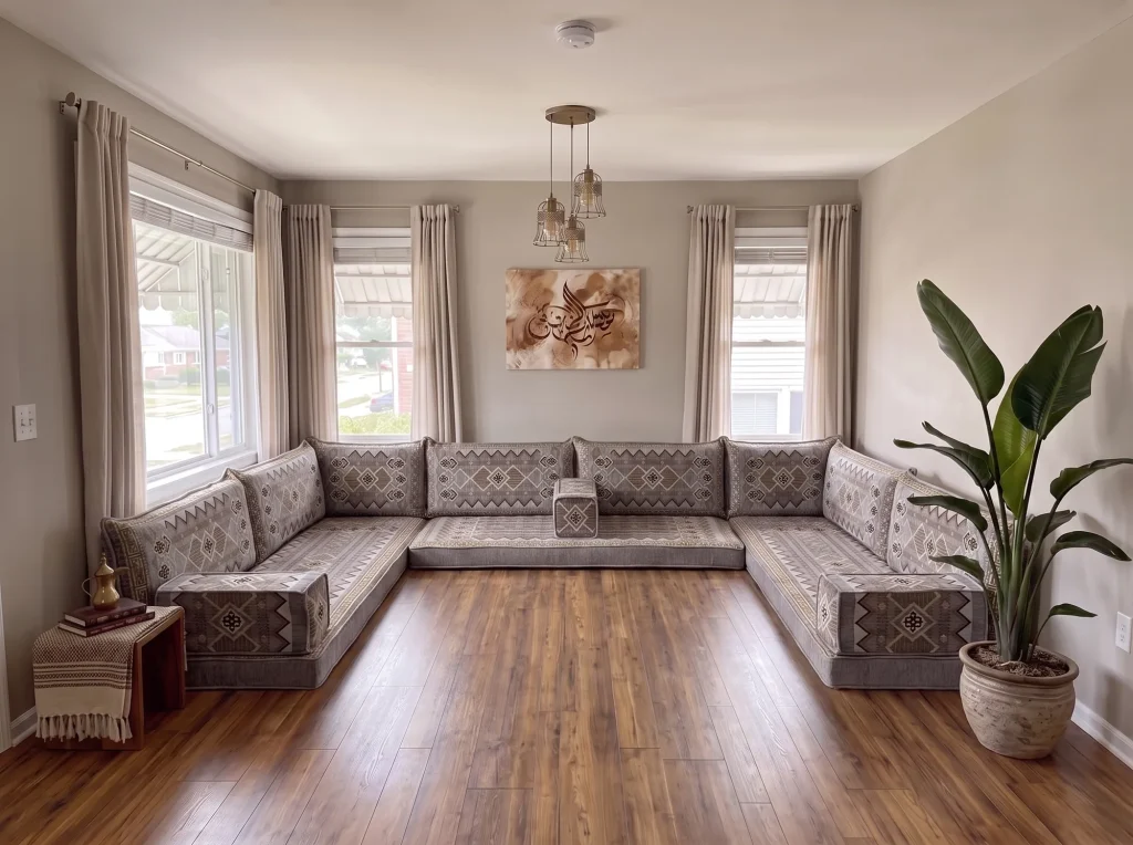 Gray and gold geometric floor sofa set in a U shape on a bare wood floor in a bright living room with calligraphy art