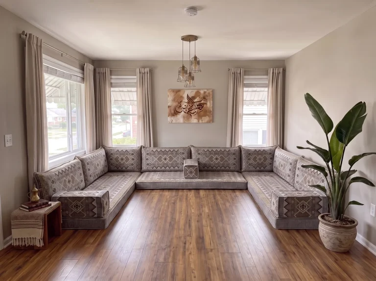 Gray and gold geometric floor sofa set in a U shape on a bare wood floor in a bright living room with calligraphy art