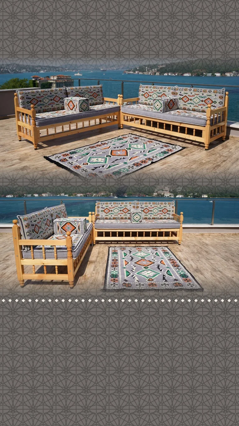 Two natural wood outdoor benches with grey kilim cushions and a matching rug on a terrace above the sea