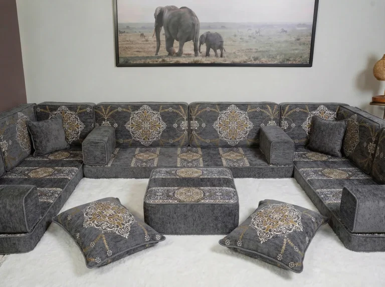 Grey chenille diwan floor sofa in a U shape with gold medallion cushions, ottoman and two floor cushions