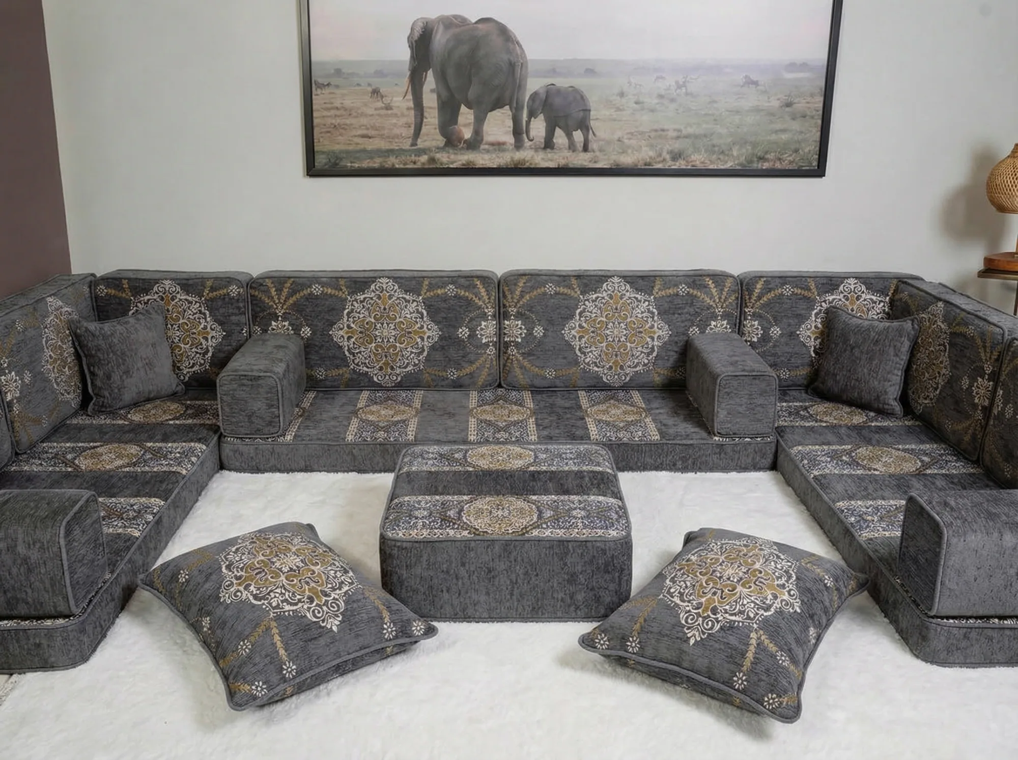Grey chenille diwan floor sofa in a U shape with gold medallion cushions, ottoman and two floor cushions