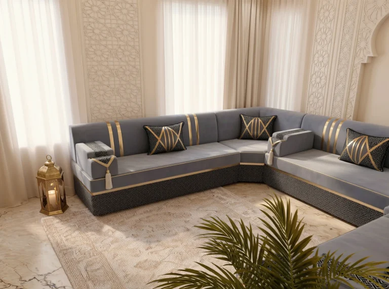 Grey and gold Arabic majlis seen across a corner with a brass lantern at the left and palm fronds in front