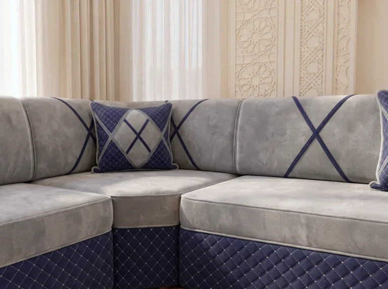 Close-up of a light grey velvet majlis sofa set corner with navy crossed bands and a quilted navy base