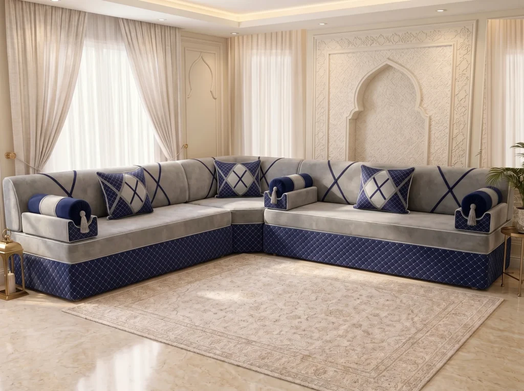 L-shaped light grey and navy Arabic majlis with quilted base and bolster armrests on a marble floor