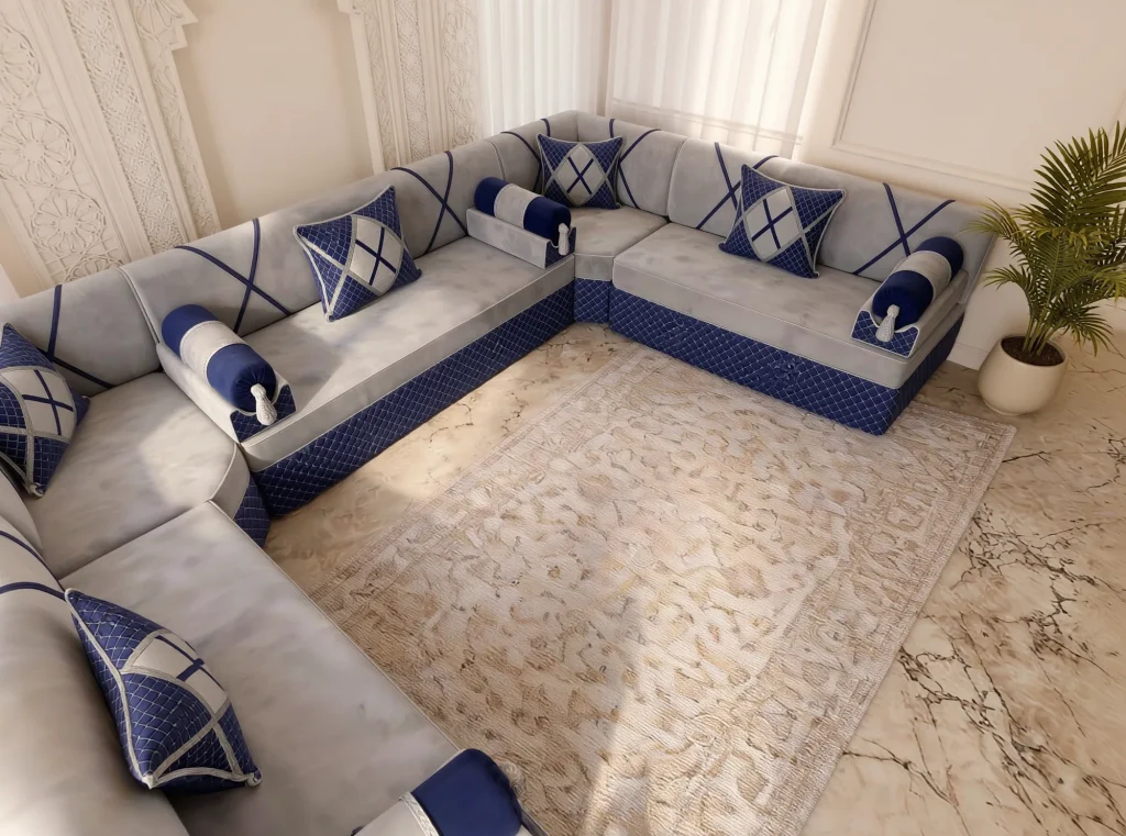 Overhead view of a light grey and navy Arabic majlis corner with bolster armrests on a veined marble floor